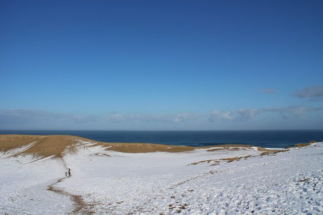 Durante o inverno, a neve transforma as praias arenosas em paisagens únicas, onde o branco gelado contrasta com o azul do mar e o dourado da areia (Foto: Suicasmo, CC BY-SA 4.0, via Wikimedia Commons)