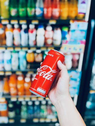 O questionamento rapidamente gerou diversas respostas, destacando que o nome Coca-Cola faz referência a dois ingredientes principais: a folha de coca, de onde se extrai a cocaína, e a noz de cola, rica em cafeína (Foto: Unsplash)